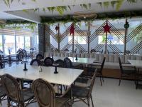 Un comedor con mesas y sillas y ventanas. en Sun on the bay beach hotel, en Palmar de Ocoa