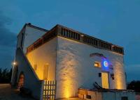 a white building with a sign on the side of it at Trappito Stracca Agriturismo in Alezio