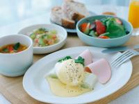 una mesa con platos de comida y cuencos de fruta en ITOMACHI Hotel 0, en Saijo