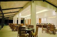 un ristorante con tavoli e sedie in legno e una sala da pranzo di Oak Ray Heritage Hotel a Kandy