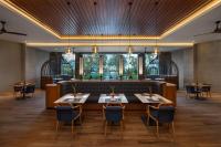 a dining room with tables and chairs and a bar at Four Points by Sheraton Bintan, Lagoi Bay in Lagoi