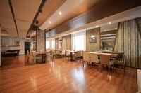 una sala da pranzo con pavimenti in legno, tavoli e sedie di Riverside Boutique Hotel a Bansko