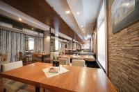 un ristorante con tavoli e sedie in legno e un muro di mattoni di Riverside Boutique Hotel a Bansko