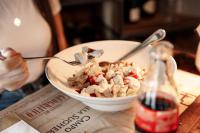 una persona comiendo un tazón de palomitas de maíz con una botella de refresco en Appartamenti Al Bivio, en Imer