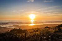 a sunset on the beach with the sun setting over the ocean at Royal Hideaway Sancti Petri in Chiclana de la Frontera