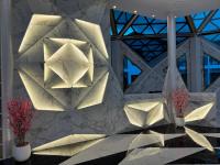 a stone wall with a light fixture and flowers on it at S3 Ayutthaya Hotel in Phra Nakhon Si Ayutthaya