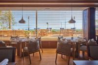 Um restaurante com mesas e cadeiras e uma grande janela. em UMITO Kamakura Koshigoe em Kamakura