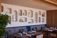 uma sala de jantar com mesas e uma parede com arcos em UMITO Kamakura Koshigoe em Kamakura