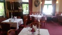 a restaurant with white tables and chairs and windows at Teichhotel in Schmalkalden