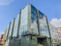 a building with glass windows on the side of it at Hotel Alcaravan Medellín in Medellín