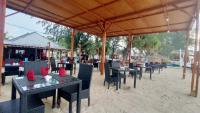 een eethoek in de openlucht met tafels en stoelen bij Matahari Bungalow 3 in Gili Air