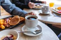 トロワ・リヴィエールにあるHôtels Gouverneur Trois-Rivièresのコーヒーを飲みながら座る人