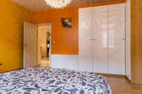 a bedroom with a bed and white cabinets and a chandelier at Gite hyper centre 10 pers in Colmar