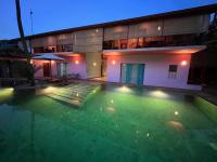 a swimming pool in front of a house at night at Dickman Resort "The Boutique Hotel" in Negombo