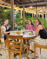 un grupo de mujeres sentadas en una mesa en OKU Guest House, en Giri