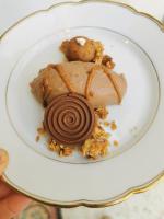 einen Teller mit einem Dessert und einem Keks darauf in der Unterkunft Château le Fresne in Bouchemaine