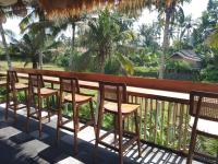 eine Stuhlreihe auf einem Balkon mit Palmen in der Unterkunft Bali View Ubud Hotel in Ubud