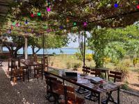 a group of tables and chairs under a tree at Bij Club in Bubaque