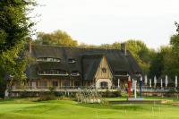 una casa con tejado abuhardillado en un campo de golf en Grand Slam, en Le Vaudreuil