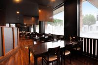 a dining room with tables and chairs and windows at Hotel Sunshine in Engaru