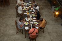 un gruppo di persone sedute a un tavolo che mangiano cibo di Ceylon Ayu Resort Kandy a Kandy