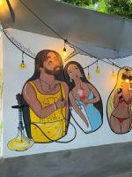 a painting of a man and woman on a wall at GRECHA Hotel in Unawatuna