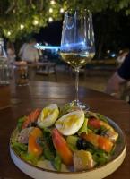 a plate of salad with eggs and a glass of wine at GRECHA Hotel in Unawatuna