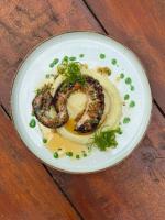 a plate of food with shrimp on a wooden table at GRECHA Hotel in Unawatuna