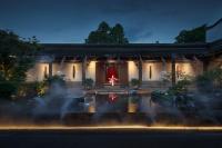 福州市にある福州三坊七巷安民半舍文化酒店Fuzhou Sanfang Qixiang Anmin Banshe Cultural Hotelの夜の池のある建物