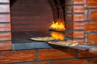 two pizzas sitting on pans in a brick oven at فندق براي Brai Hotel in Ad Dawādimī