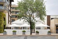 アデレードにあるMajestic M Suitesの白い傘がついた建物の前の木