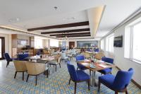 uma sala de jantar com mesas e cadeiras azuis em Fortune Beachfront, Puri - Member ITC Hotels' Group em Puri