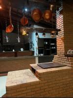 una cucina con pentole e padelle appese a un muro di mattoni di Chalé Estância do Coruja a Salesópolis