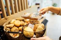 瓦尔德基兴Camping Resort Bayerwald的一个人将面包倒入食物篮中。