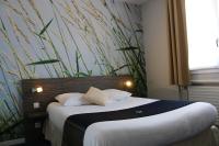 ブロンにあるThe Originals City, Hôtel Dau Ly, Lyon Estの壁に大きな絵が飾られたベッドのある寝室