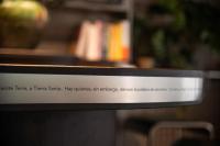 Un cartel encima de un estante con un libro. en Adventure Hostel Madrid, en Madrid