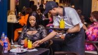 a man handing a woman a tray of food at Sigma Base Apartments in Lagos