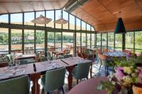 Un restaurante con mesas, sillas y ventanas. en Prosper Maufoux - Château de Saint-Aubin, en Saint-Aubin