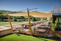 un restaurante con mesas y sillas bajo una sombrilla amarilla en Prosper Maufoux - Château de Saint-Aubin, en Saint-Aubin