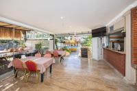 ダルヤンにあるLegend Of Dalyan Hotelのテーブルと椅子とキッチンのあるレストラン