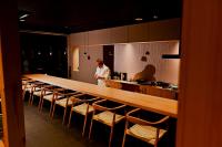 un uomo in piedi in una cucina con un lungo bancone di Haku Fuji Yamanakako a Yamanakako