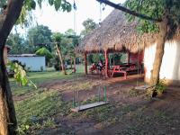 un gruppo di persone sedute su un'altalena fuori da una capanna di Hostel Los Chocoyos a Ometepe