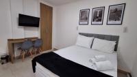 a bedroom with a bed and a desk and a television at Flat Casa Mauá in Rio de Janeiro