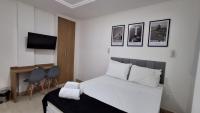 a bedroom with a bed and a desk and a television at Flat Casa Mauá in Rio de Janeiro