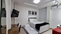 a small bedroom with a bed and a television at Flat Casa Mauá in Rio de Janeiro