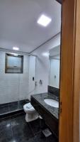 a bathroom with a toilet and a sink and a mirror at Flat Casa Mauá in Rio de Janeiro