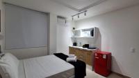 a small room with a bed and a small kitchen at Flat Casa Mauá in Rio de Janeiro