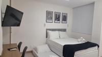 a bedroom with a bed and a flat screen tv at Flat Casa Mauá in Rio de Janeiro