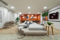 a bedroom with two beds and a living room at Flat Casa Mauá in Rio de Janeiro
