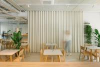 un restaurante con mesas de madera, sillas y cortinas en Carlotta Apartments, en Berlín